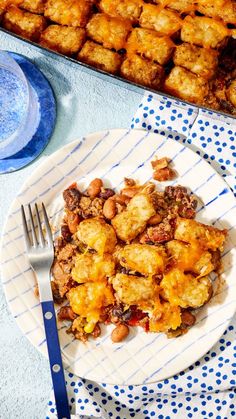 a white plate topped with tater tots next to a blue and white table cloth