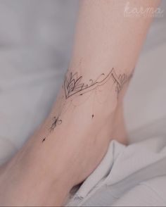 a person with a tattoo on their foot is laying in bed and looking at the camera