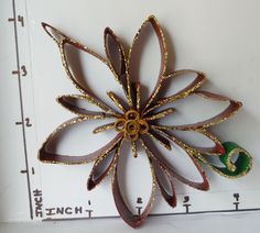 a brooch that is sitting on a ruler