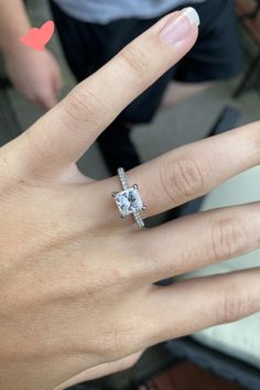 a woman's hand with a diamond ring on it