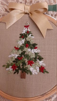 a cross stitch christmas tree with red and white flowers