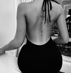 the back of a woman's body with tattoos on her upper and lower back