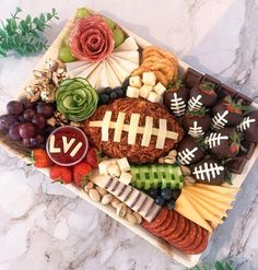 a football themed platter with cheese, crackers and fruit