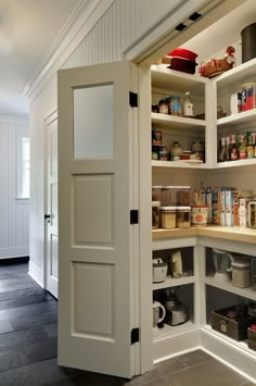 an open pantry door in the middle of a room with shelves and other items on it