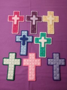 crocheted crosses are arranged on a purple background