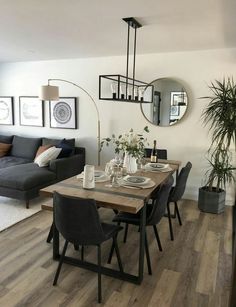 a living room with a couch, dining table and mirror on the wall above it