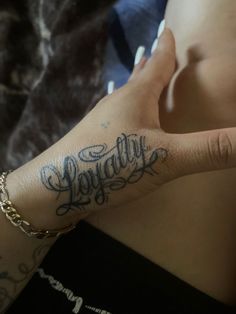 a woman's hand with the word happily tattooed on her left arm and wrist