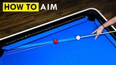 a man is playing pool on a blue table with the words how to aim above it