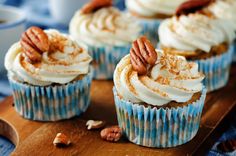 several cupcakes with frosting and nuts on top