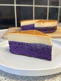 two pieces of cake on a plate with purple and white frosting, sitting on a counter