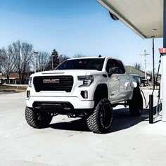 a white truck parked at a gas station