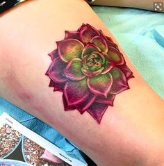 a woman's leg with a tattoo on it that has a succulent flower