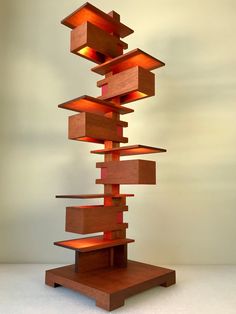 a tall wooden sculpture with lights on it's sides and shelves in the middle