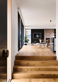 the interior of a modern home with wood flooring