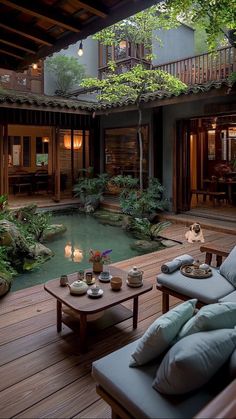 an outdoor living area with couches, coffee table and water feature in the center