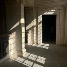 the sun is shining through the windows in an empty room with stone floors and columns