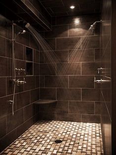 a bathroom with tiled walls and floor, shower head light on the wall next to the bathtub