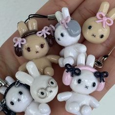 a person is holding some cute little keychains in their hand and it looks like they are wearing bunny ears