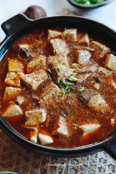 tofu is in a black bowl on a table