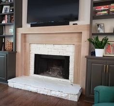 a living room with a fireplace and tv above the fire place in front of it