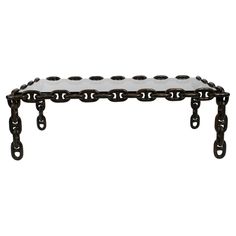 a black and white bench with chains on it