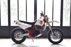 a white and red dirt bike parked in a garage