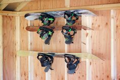 two snowboards mounted to the side of a wooden wall with sandals hanging on it