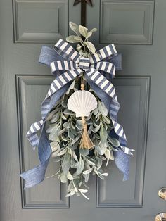 a blue and white wreath on the front door with a star hanging from it's side