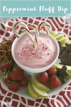 a plate with apples, strawberries, pretzels and candy canes on it