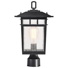 an outdoor post light with a clear glass shade on the top and black metal base