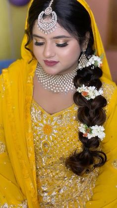 a woman wearing a yellow outfit with flowers in her hair and jewelry on her head