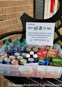 a plastic container filled with lots of food and drinks sitting on top of a bench