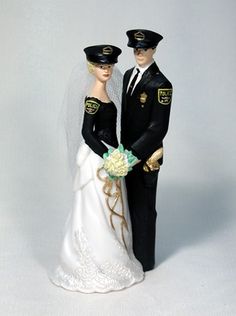 a bride and groom figurine standing next to each other on a white background