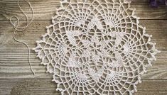 a crocheted doily on a wooden surface