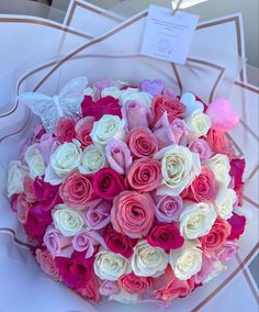 a bouquet of pink and white roses on a table