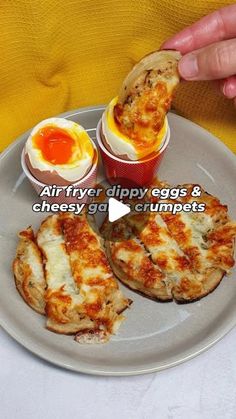 a person is holding an egg and cheese cupcakes on a plate with the words air fryer appetizers & cheesy eggs crumpets