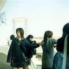 some people are standing on a bridge and one is holding a cell phone in her hand