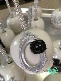 there is a black rose on top of some white balls