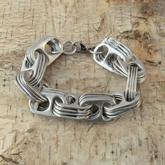 a silver bracelet on top of a wooden table