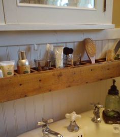 a white sink sitting under a window next to a wooden shelf filled with bathroom items