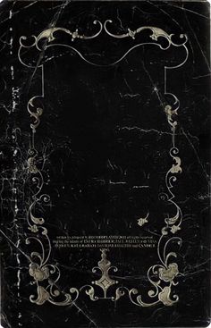 an old black book with white swirls and scrolls on the cover, in front of a dark background