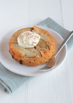 a white plate topped with an apple pie on top of a blue napkin next to a fork