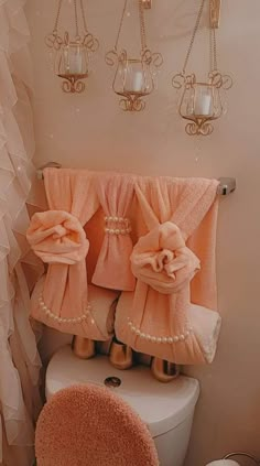 a bathroom with pink towels hanging on the wall and a toilet in front of it