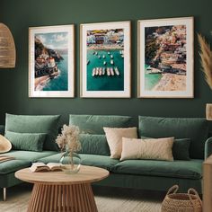 a living room with green walls and pictures on the wall above the couch, along with a coffee table