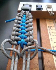 a close up of a blue and gray knot on a piece of wood with a ruler in the background