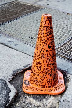 an orange traffic cone sitting on top of a sidewalk