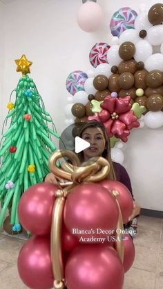 a woman holding balloons in front of a christmas tree