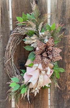 a wreath is hanging on the side of a wooden fence