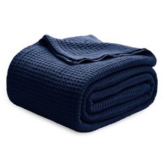 a blue blanket folded on top of a bed