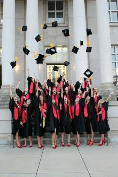 a group of graduates throwing their caps in the air on steps outside an old building